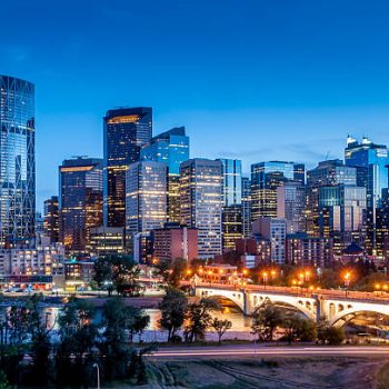 Calgary skyline at night with Bow River and Centre Street Bridge.